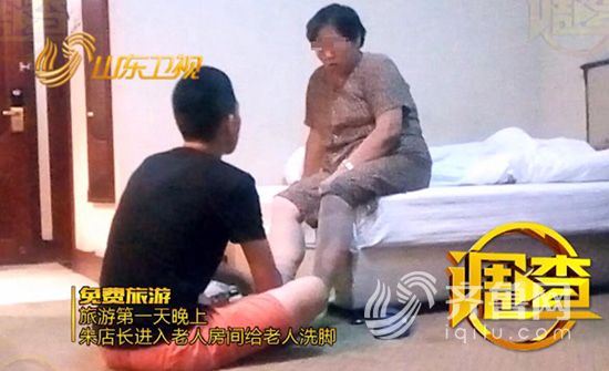 朱店长坐在地上给老人洗脚。视频截图