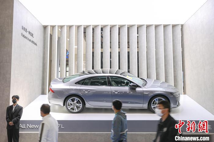 图为2022第十七届南昌国际汽车展现场，几位市民从一辆参展新能源汽车前走过。　刘力鑫 摄