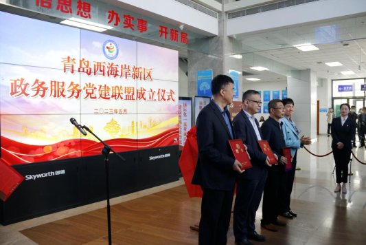 图四 5月11日，青岛市首个政务服务党建联盟在西海岸新区举行揭牌仪式，同时举行首次党建联盟成员大会，通过了联盟章程，选举产生了第一届理事会和理事长、副理事长、秘书长。图为会上，与会领导为新区政务服务党建联盟指导单位颁发了聘书。（胡全福 摄）