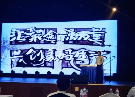 图为邮储银行济南市分行工作人员在文艺演出上进行沙画表演