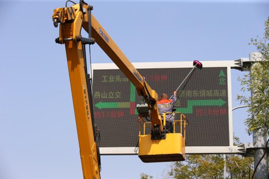 4、2023年10月17日，环卫工人正在山东省济南市龙鼎大道打扫清洁交通信息牌。
