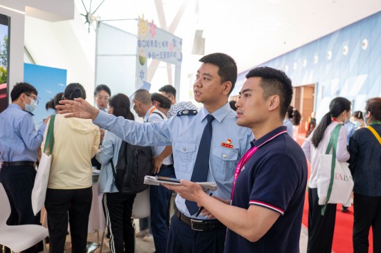 海口市税务局党委委员、总经济师李由向人民网记者介绍展台工作情况。人民网记者 翁奇羽摄