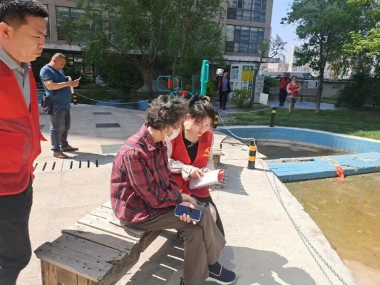 社區(qū)志愿者向群眾征求意見建議。