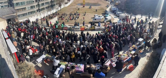 游客在八陡老街广场排队领取免费大锅菜