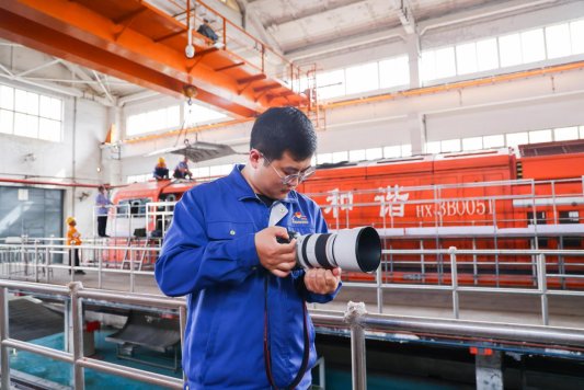 图为钮圣杰在机车检修库房拍摄作业场景2