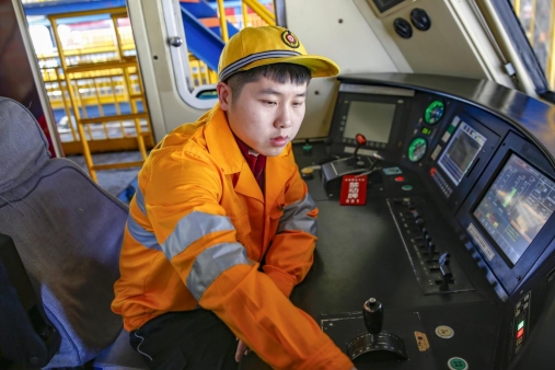 济南电务段济南车载设备车间工长韩佳林在检查列车司机室内车载信号设备