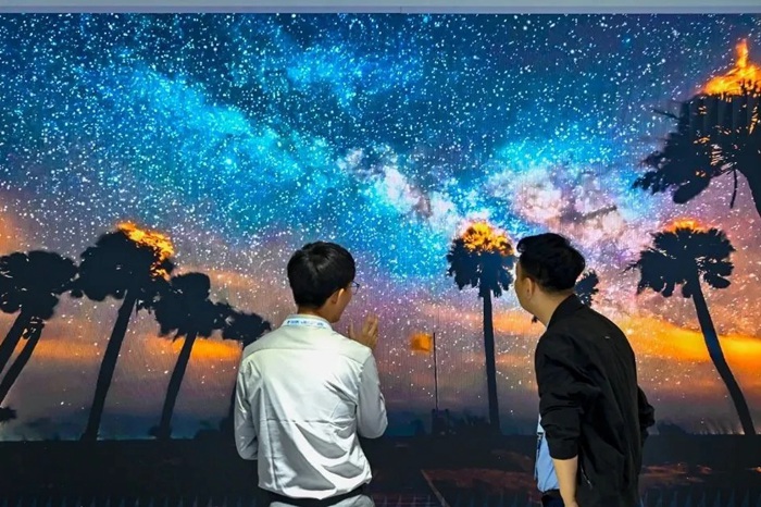 长春光博会希达电子展区,一位工作人员正在给一位观众讲解。(长春新区供图)