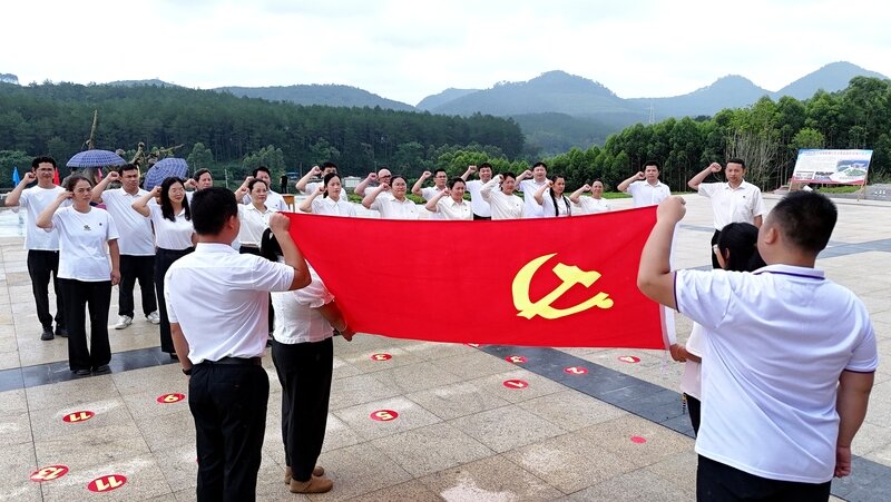 2025年7月1日,广西都宜忻人民解放总队纪念馆前,党员面向党旗重温入党誓词。