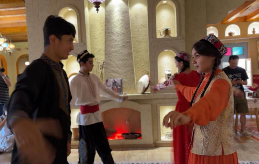 在团城一家特色店铺内,演员为游客表演舞蹈。人民网记者 焦磊摄