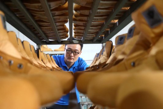 6-2025年9月12日，在山东潍坊高密市奥龙鞋业有限公司，工人在车间整理产品。（李海涛 摄）