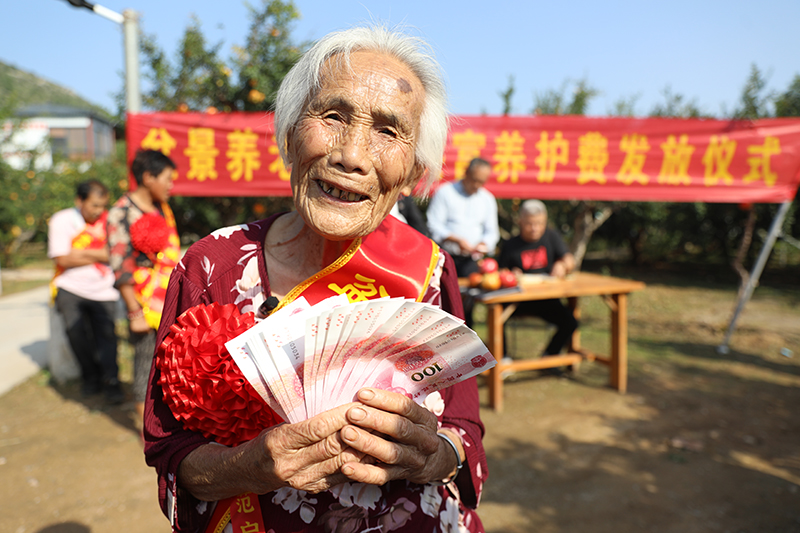 孙大娘手拿“养护费”,笑得合不拢嘴。孙慧摄