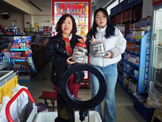 张金梅（左一）与儿媳共同直播销售咸螃蟹