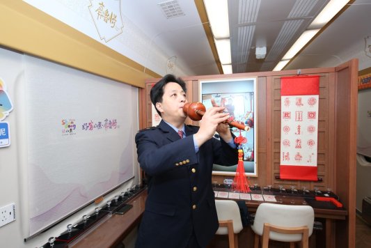 职工张智勇演奏乐器葫芦丝(姜艾勇摄)