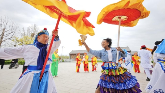 《文化互鉴绽光彩》刘志海12389112789-2025年4月18日，山东“非遗文化人才交流互鉴”活动暨“山东财经大学国际教育学院中华优秀传统文化社会实践基地”揭牌仪式在商河举行。国家级非遗商河鼓子秧歌队员与外国友人共同起舞，不同文化元素彼此互动融合，中外文化在交流中互鉴、在互动中绽放光彩。