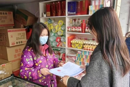 图为工作人员为偏远零售户送证上门
