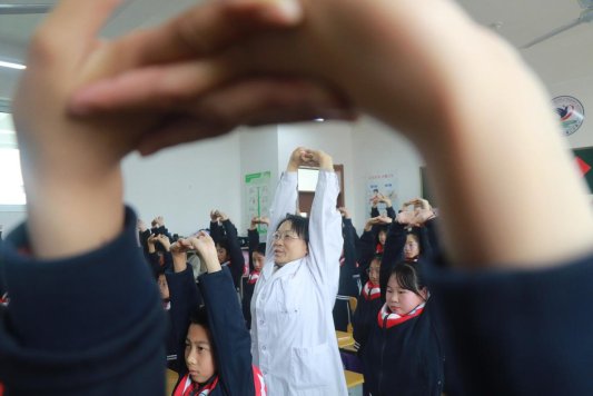 1-主管护师董绪存带领小学生做脊柱健康操