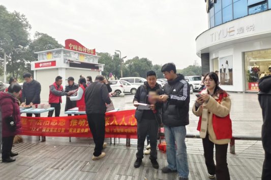 图为专卖人员在商圈向群众讲解假烟鉴别技巧