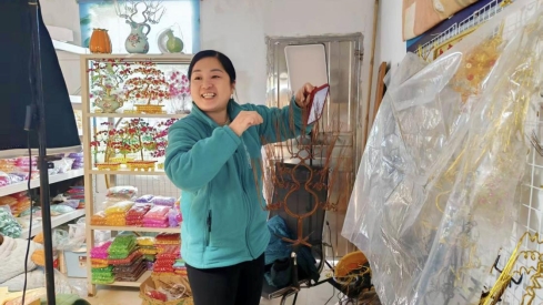 图为贾山红直播用铁丝制作工艺品