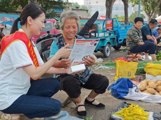刘海燕在口镇大集向集市上的摊主普及金融知识1