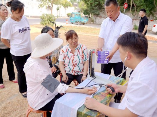 图为工作人员对当地群众进行血压、血糖检测_副本