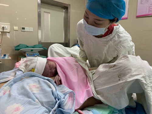 一位助产士正在对新生儿进行护理全程陪护产妇的人张倩和郭素梅都是