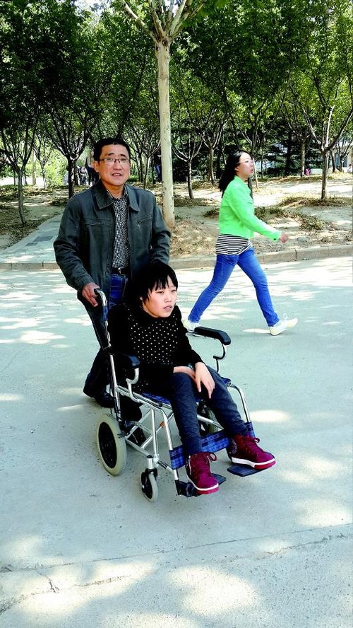 轮椅女生靠父亲推着上课 称这辈子要为自己负责