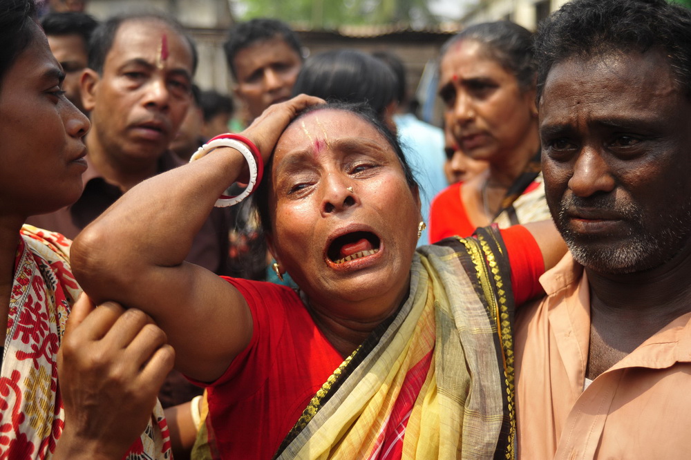 3月27日，在孟加拉国首都达卡附近的纳拉扬甘杰地区，一名妇女见到家人的遗体后失声痛哭。