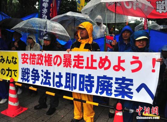 9月17日，众多日本民众冒着大雨持续聚集在国会周边进行反安保抗议活动。中新社发 王健 摄