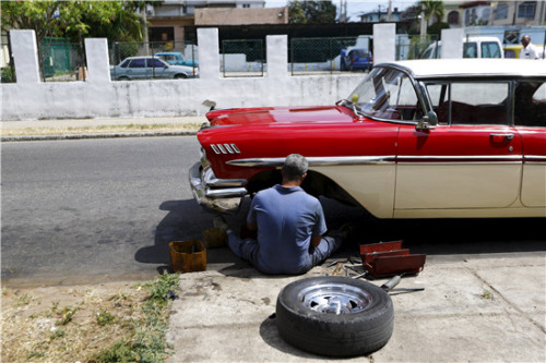 2016年3月17日，一名男子在哈瓦那街边修理一辆老式汽车。（图片来源：路透社）