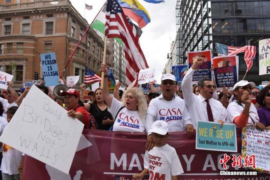 资料图：5月1日，在美国首都华盛顿，示威人群在杜邦环岛举行集会后，一直行进到白宫北面的拉法耶特广场，抗议特朗普的移民政策等。