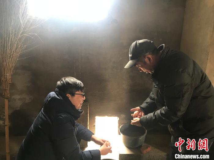 戚允升与王旭红收获鸡蛋。　孙军 摄