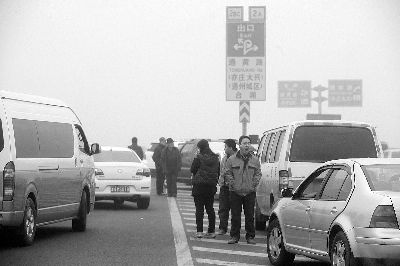    上午，京津高速出京方向，因大雾封路车主将车停在路边等待通行  摄/法制晚报记者 付丁