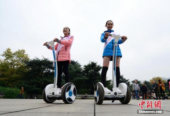 11月26日，校花平衡车挑战赛在长沙举行，参加世界旅游文化小姐中国总决赛的20余所高校校花同场竞技，吸引了众多市民围观。主办方表示，希望用这种独特的方式倡导市民低碳出行，爱护环境。 杨华峰 摄