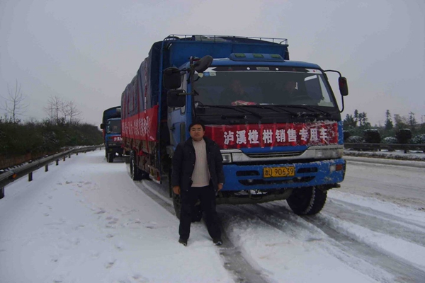 2008年冰灾期间，谭永峰在外运椪柑的销售车前。资料图