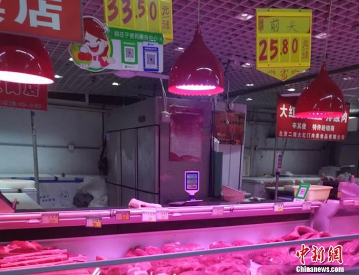 图为北京丰台区一家菜市场内的猪肉摊。 谢艺观 摄