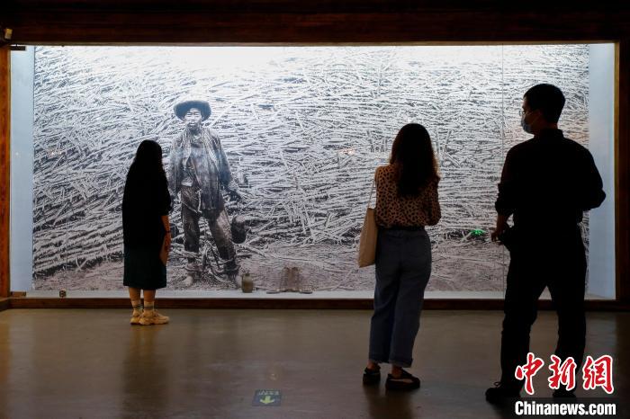 图为江门五邑华侨华人博物馆展示的一张早期中国移民照。该移民被骗往南美甘蔗种植园，工作时还佩戴脚镣。　王骏 摄