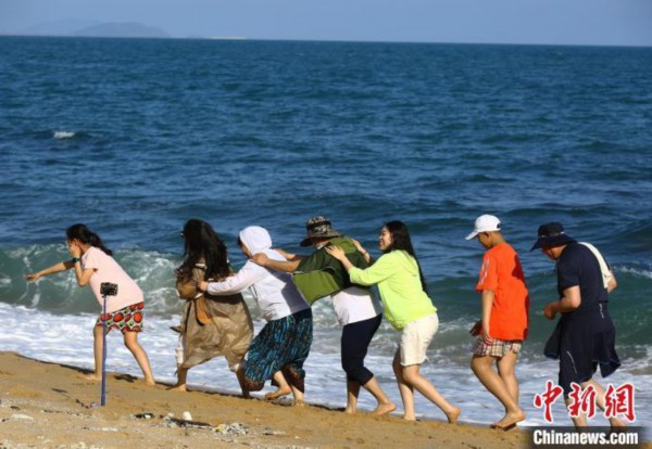  5月3日，游客在三亚南山文化旅游区海边游玩。　陈文武 摄