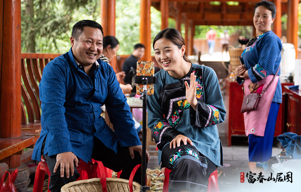 在湘西十八洞村，十八洞村扶贫队长与返乡大学生一起直播推销土特产。