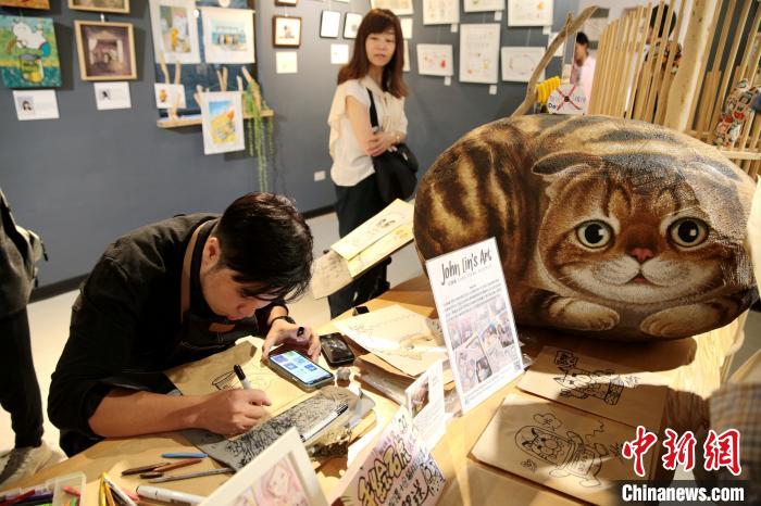 图为画家正在创作猫咪画。　张远　摄