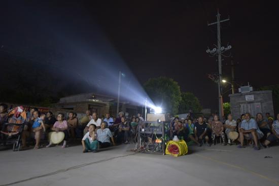 6月24日，在贾寨镇堤头袁村，电影下乡演出现场，人们在观看电影《第九个女婿》。