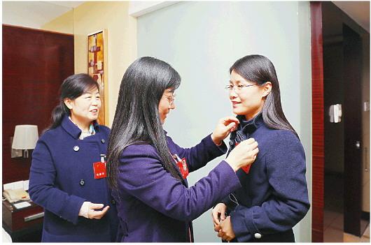2月12日,出席省十三届人大二次会议的东营团代表刘芳美、张莉芳、王涛(从左至右),向大会报到后,佩戴代表证。□记者　王世翔　报道