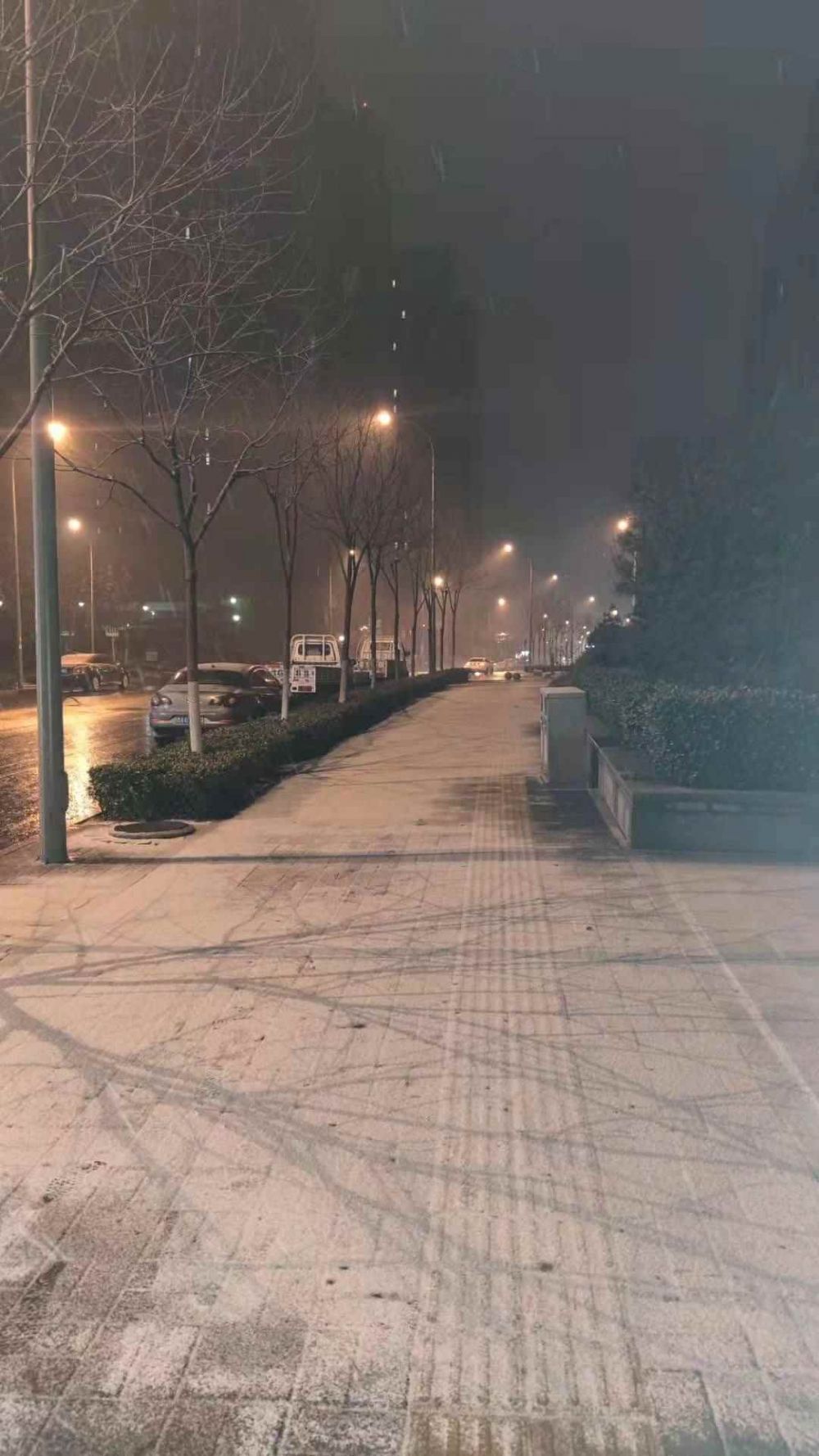 28日晚10点左右，济南市高新区舜义路人行道有了一层薄薄的白雪。