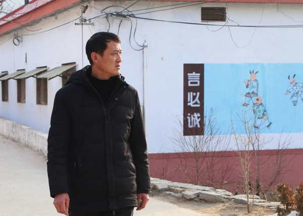 蒙阴县垛庄镇西孟良崮村党支部书记张玉坤站在村路远望。
