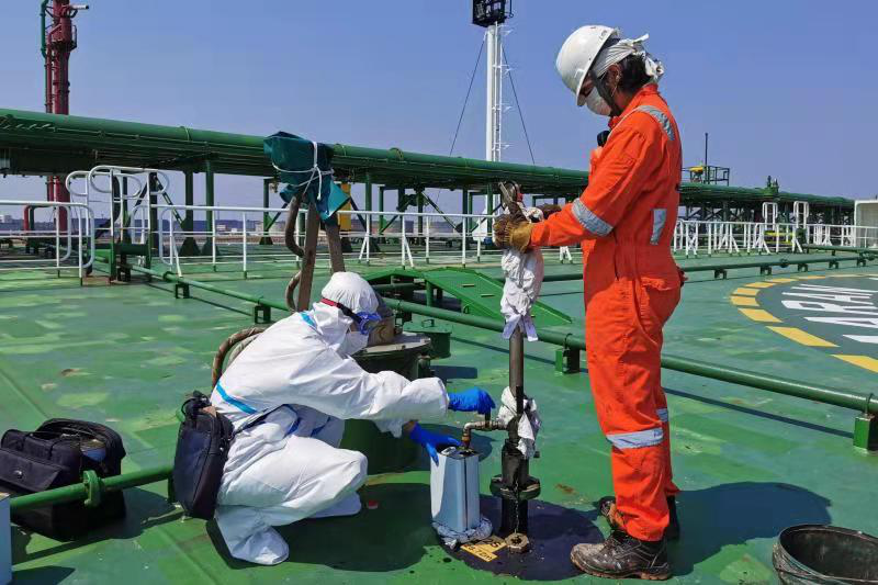 图为黄岛海关关员登轮对进口油品实施取样检验。图片来源:青岛海关