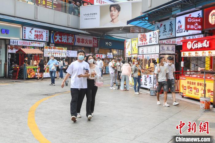 图为江西南昌一美食街，不少市民在逛街品尝美食。　刘力鑫 摄