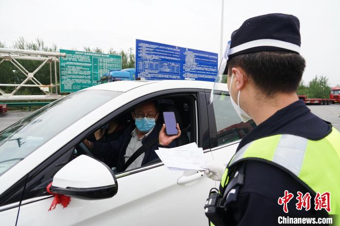 图为城东公安分局执勤民警查验&ldquo;两码一报告&rdquo;。　马铭言 摄