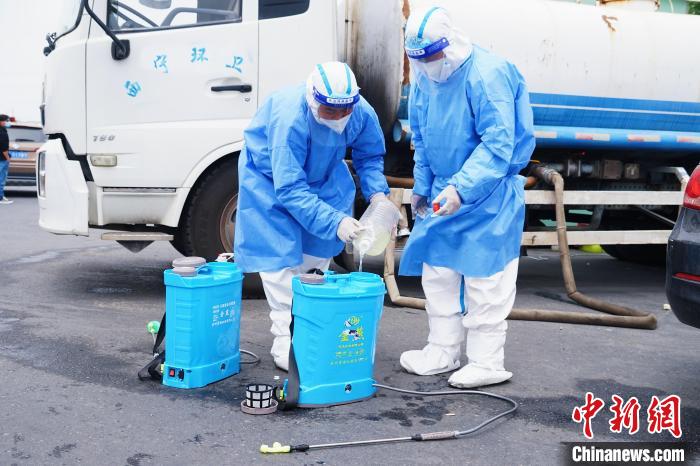 图为环卫部门工作人员做消杀前的准备工作。　马铭言 摄