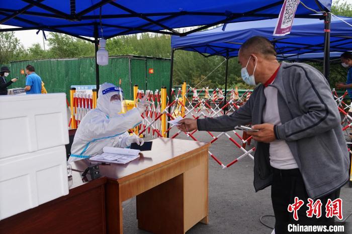 图为城管部门工作人员登记来宁返宁人员信息。　马铭言 摄