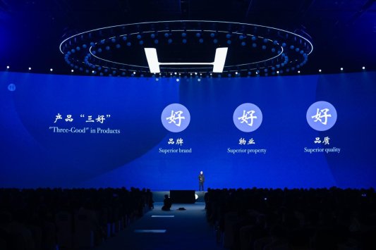 A person standing on a stage with a large screen

AI-generated content may be incorrect.