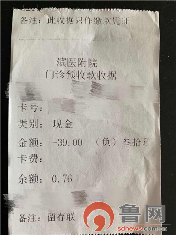 在滨州医学院附属医院综合楼一楼的挂号收款窗口外多人在排队办理充值